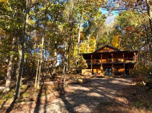 A cabin surrounded by trees, with a clear path leading to it. - Sunset Ridge Cabin in Hocking Hills (Logan)