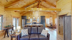 A cozy cabin interior with a dining area, kitchen, and seating space.