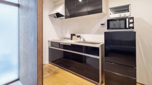 Une cuisine compacte équipée d’un four à micro-ondes, d’un grille-pain et d’un évier.