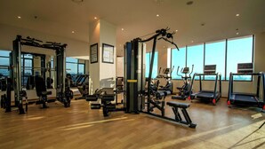 A gym with various exercise equipment, large windows, and a wooden floor. - Best Western Plus Kathmandu Hotel (Kathmandu)