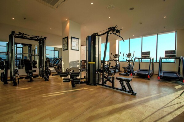 A gym with various exercise equipment, large windows, and a wooden floor. - Best Western Plus Kathmandu Hotel (Kathmandu)