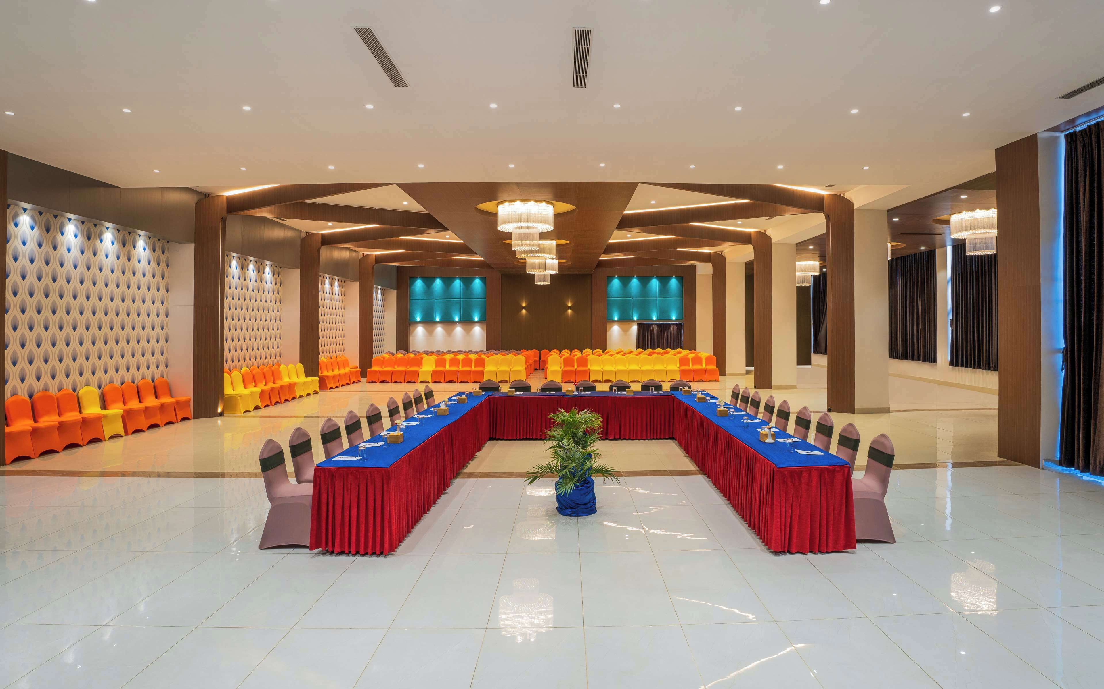 A conference room with a long table, rows of chairs, and a modern ceiling design.
