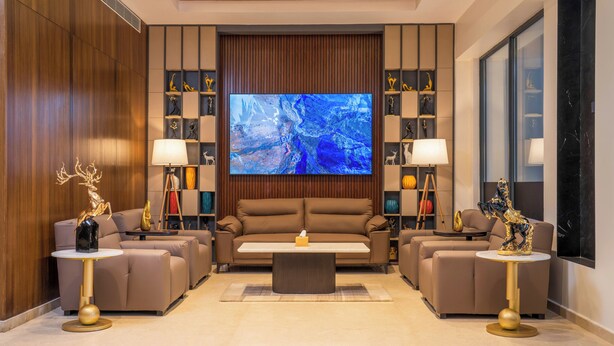 A modern living room with a large flat-screen TV, two sofas, and a coffee table. - Best Western Plus Kathmandu Hotel (Kathmandu)
