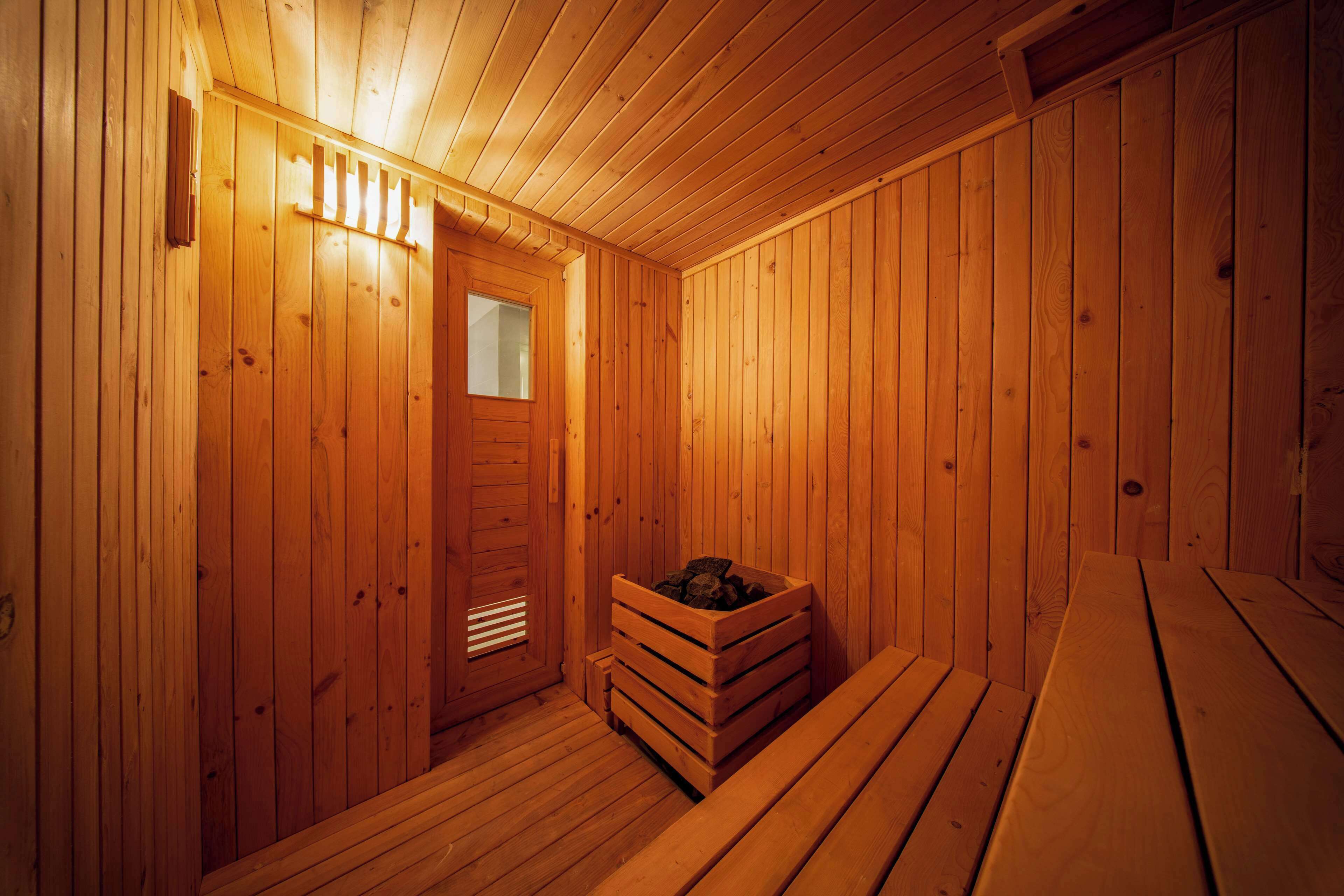 A wooden sauna room with benches and a bench with a log.