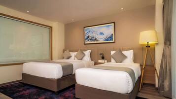 A hotel room with two beds, a large window, a painting on the wall, and a floor lamp.