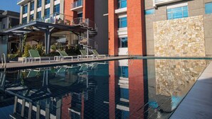 A hotel with a swimming pool, multiple floors, and a prominent red and white facade. - Best Western Plus Kathmandu Hotel (Kathmandu)