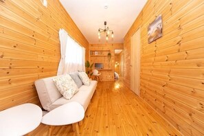 A wooden interior with a sofa, chairs, and a small table. - Yokkaichi Motomachi Hotel (Yokkaichi)