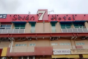 A building with a sign reading 'Seven 7 Hotel' and a storefront below with 'Mr Bread' and 'Sunflower Pasta' signs. - Seven Hotel (Putatan)
