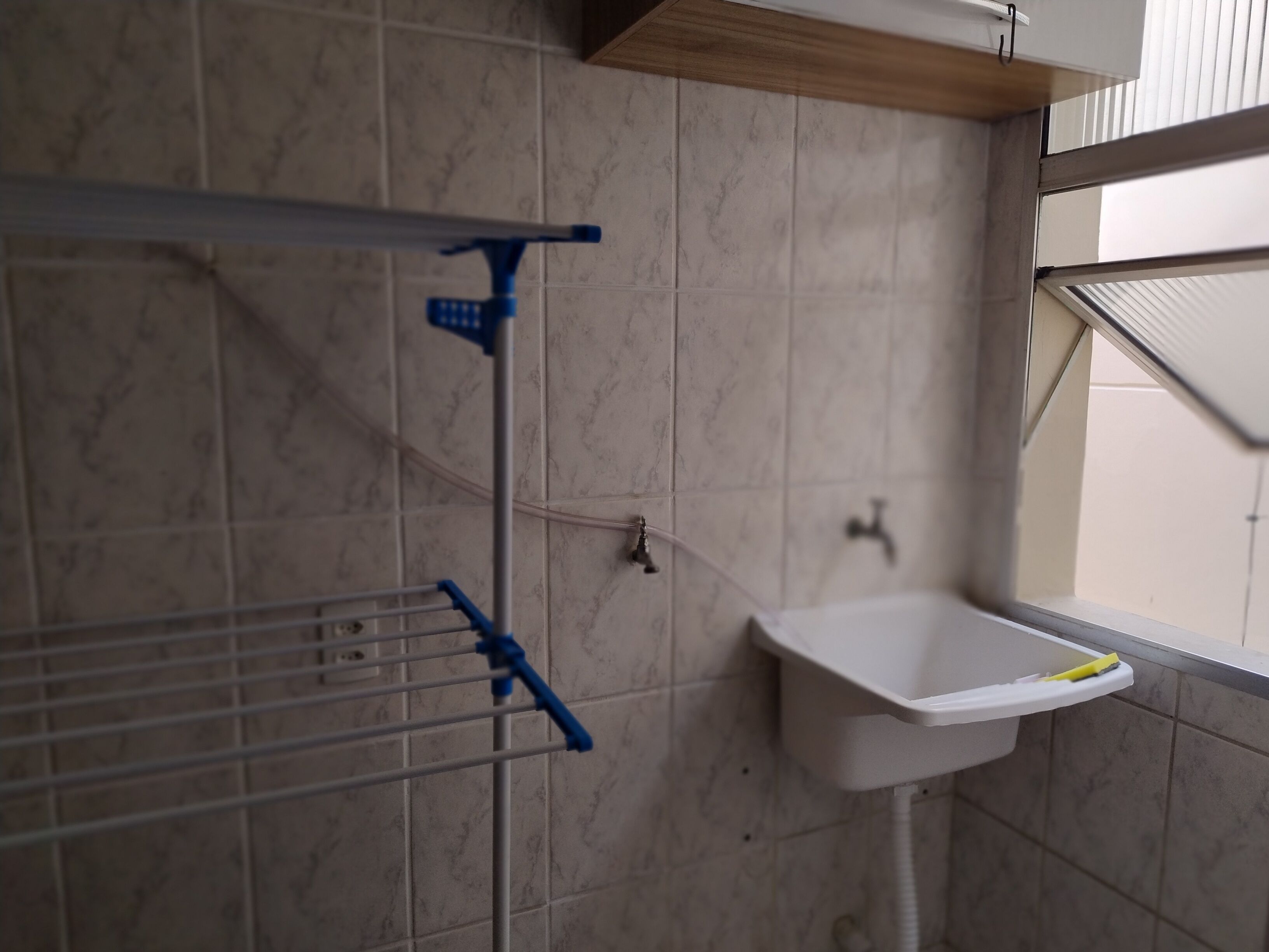 Une salle de bain avec un lavabo blanc, un porte-serviettes et un espace douche.