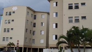A multi-story residential building with a flat facade, multiple windows, and a gated entrance. - Easy to locate apartment with air conditioning (Itupeva)