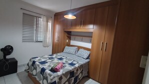 A bedroom with a bed, wooden wardrobe, and a ceiling fan. - Easy to locate apartment with air conditioning (Itupeva)