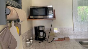 A kitchen with a microwave on a wooden shelf, a coffee maker, and a sink. - Escape to Paradise at Venus Lodging House, Alto Boquete (Alto Boquete)
