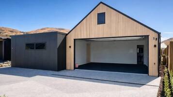 A modern building with a garage, a small window, and a clear sky.