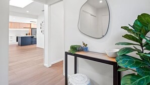 A modern kitchen with wooden flooring, a black-framed mirror, and a potted plant. - Remarkable stay in Queenstown (Jacks Point)