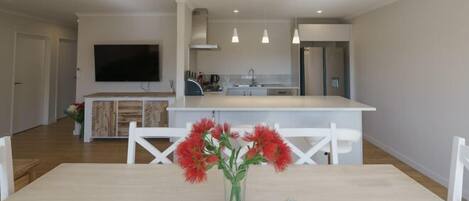 A modern kitchen with a central island, white cabinetry, and pendant lighting.