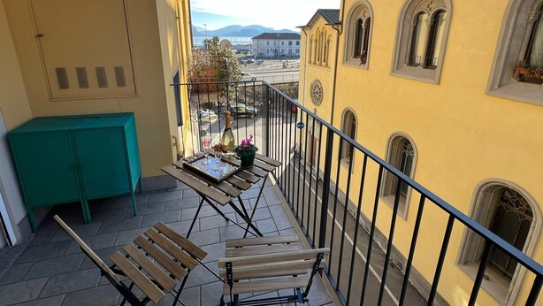 Ein Balkon mit Tisch, Stühlen und einer Weinflasche.