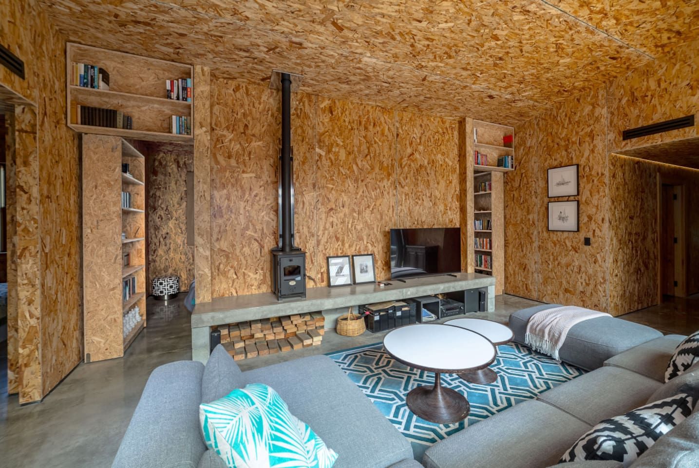 Un salon chaleureux avec une cheminée, des étagères à livres et un coin salon confortable.