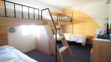 A bunk bed room with a ladder, a desk, and a chair.