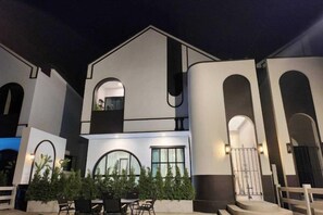 Un immeuble à plusieurs étages, doté de fenêtres en arc de cercle et d’un balcon.