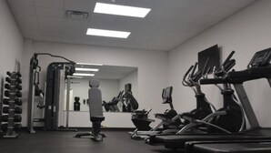 A gym with treadmills, a weight bench, and a squat rack.