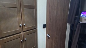A bedroom with a wardrobe, a door, and a bed. - Cozy RV in peaceful Sandia with WiFi, AC,Lake Corpus Chrisit Access nearby (Sandia)