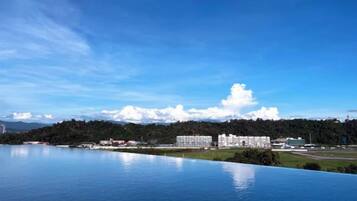 A large body of water reflecting buildings and a clear sky.