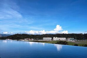 A large body of water reflecting buildings and a clear sky. - Restful Respite Tanjung Aru Inifnity Pool 2BR (Kota Kinabalu)