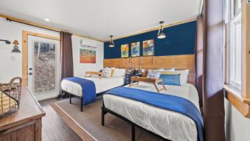A bedroom with two beds, a wooden headboard, and a window with curtains.