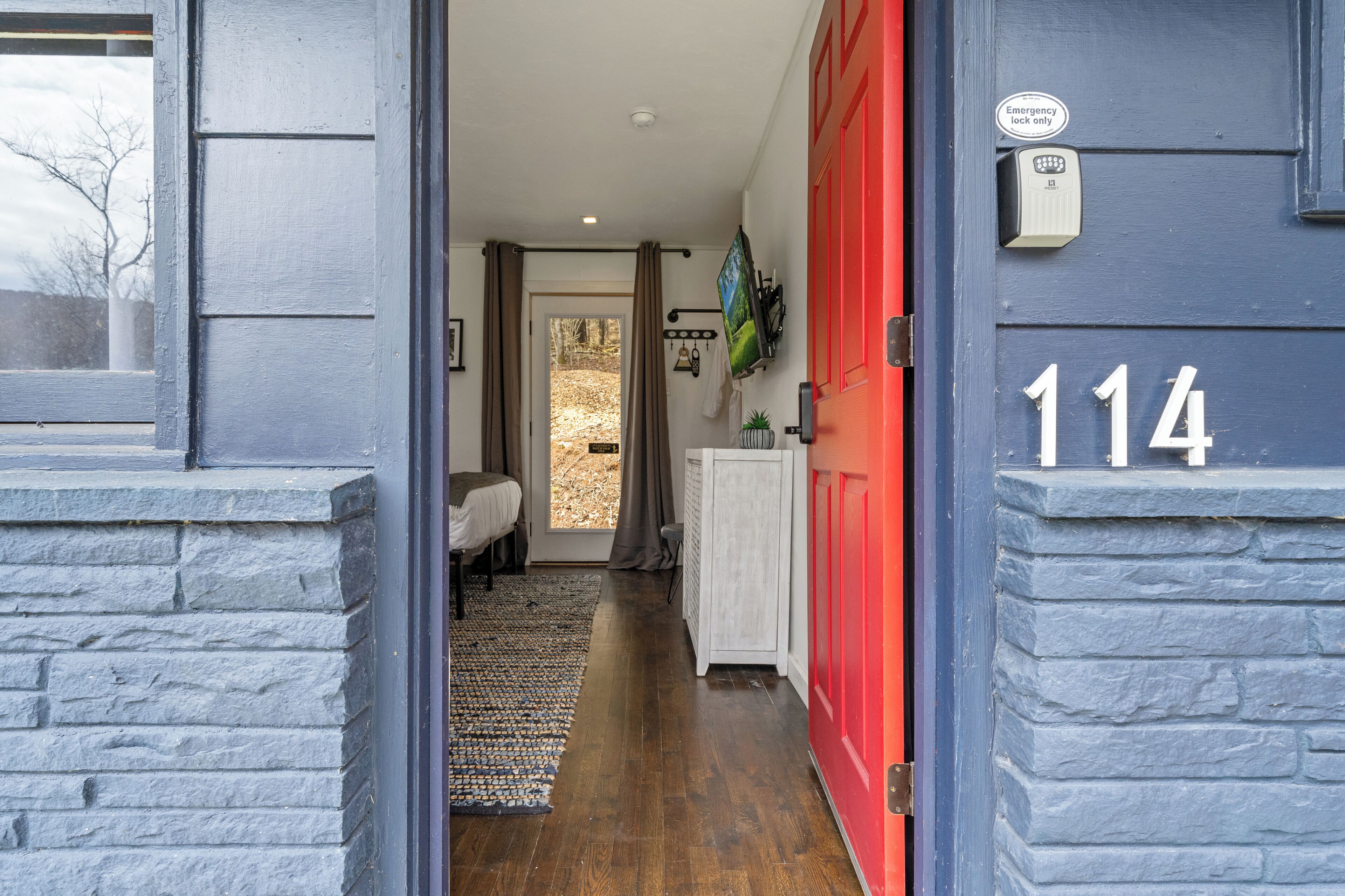 A hallway with a red door marked "114" and an emergency lock.
