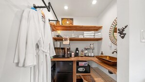 A compact kitchen with a black refrigerator, wooden shelves, a wooden countertop, a sink, and a decorative deer head. - Green Acres Retreat  (Hancock)