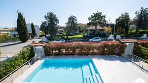 A swimming pool with a clear blue water surface, surrounded by a white tiled deck. - Villa Liliana - Apt 06 (Sirmione)