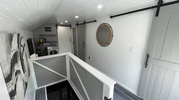 Un intérieur moderne aux couleurs claires, avec un escalier et un espace cuisine.