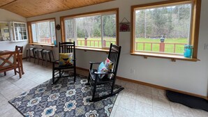 A room with large windows, wooden ceiling, and a patterned rug. - “Wake Up by the Lake — Private Alaska Stay Near Hiking & ATV Trails” (seward)