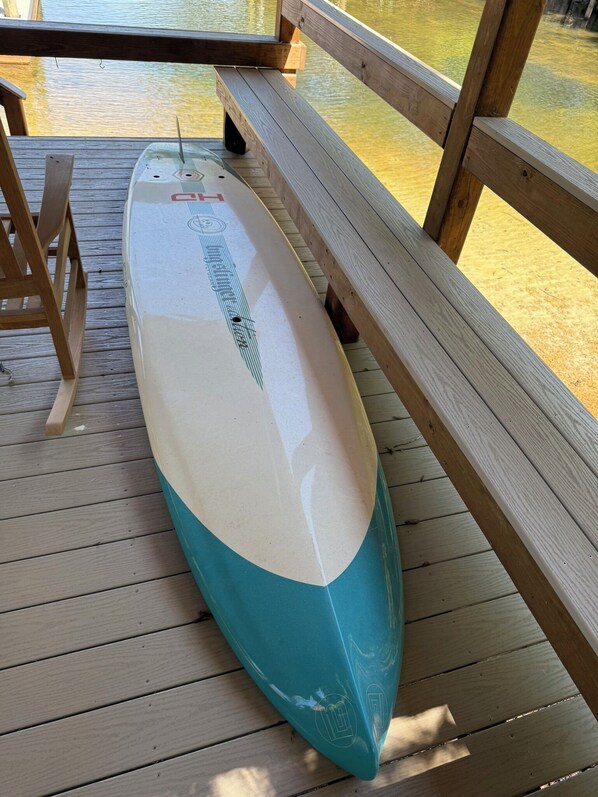 Una tavola da surf su un pontile di legno con una panca.