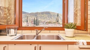 A kitchen with a sink, a glass, and a potted plant. - Appartamento Il Moresine (Roe Volciano)