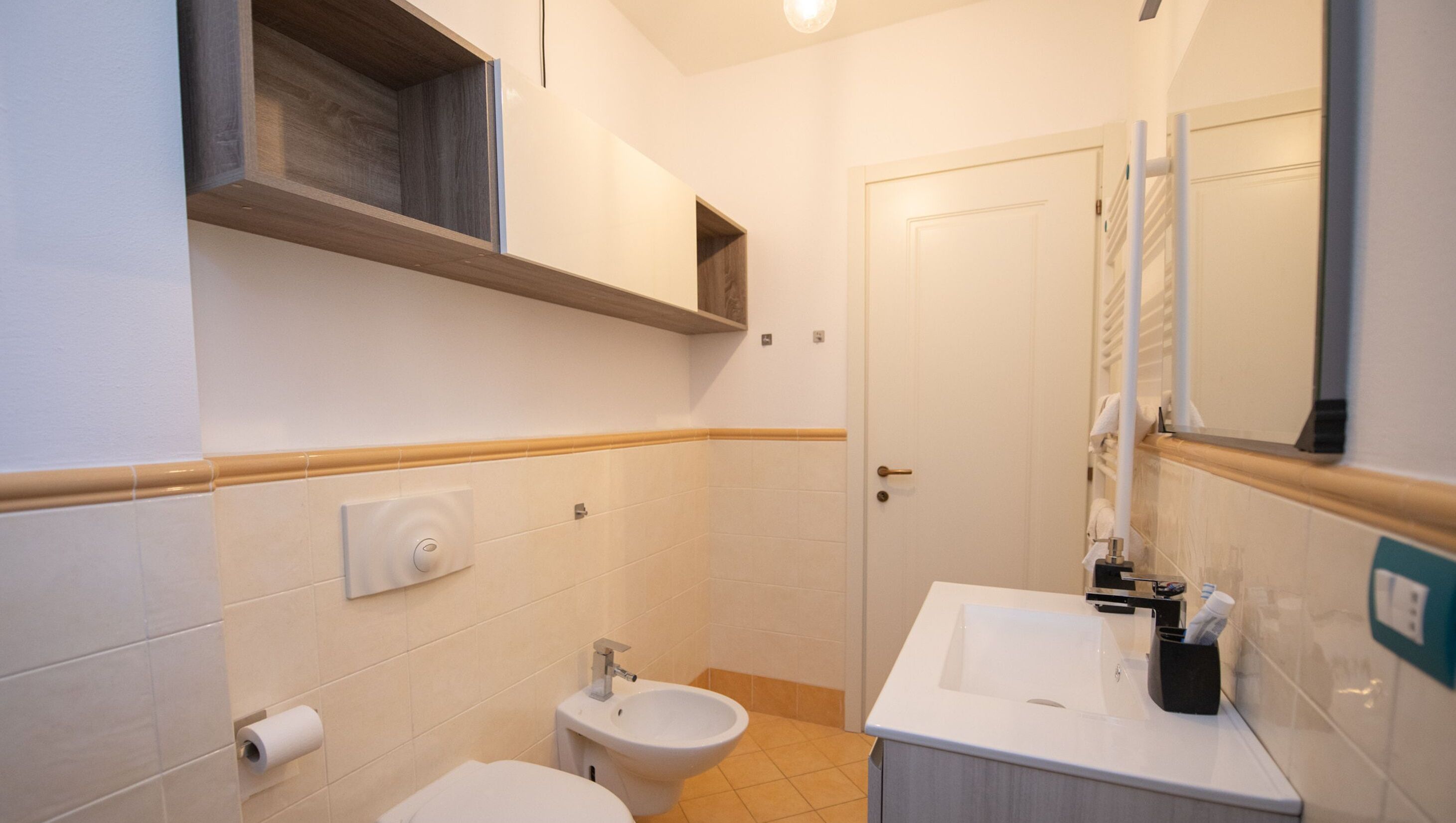 A compact bathroom with a toilet, bidet, and sink.