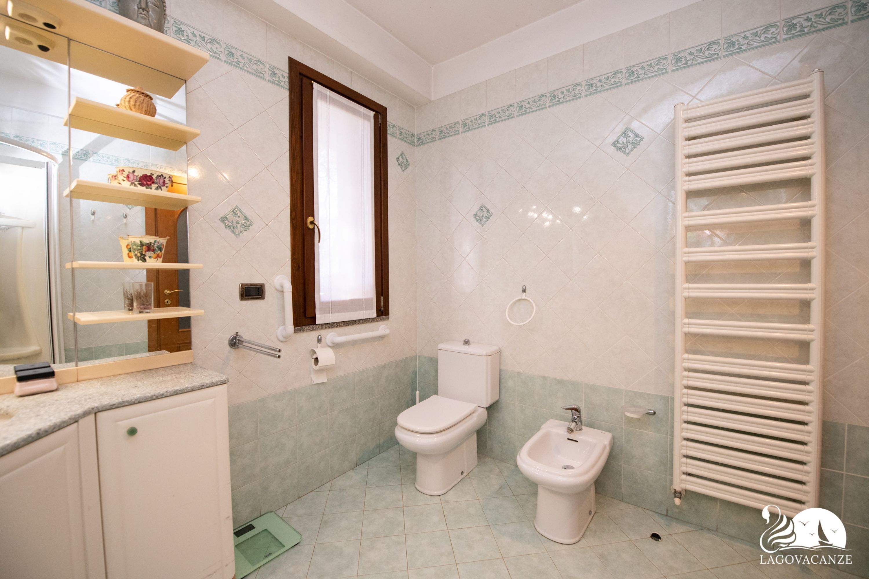 Une salle de bain équipée de toilettes, d’un bidet et d’un porte-serviettes.