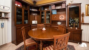 A dining room with a wooden table and chairs, surrounded by built-in bookcases and cabinets. - Casa Celestina in Padenghe sul Garda (Padenghe sul Garda)