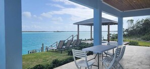 A covered outdoor seating area with a view of the sea, a gazebo, and a table with chairs. - Private oceanfront home, 10 min drive to sandy beach
Beautiful SerenityBlu (Rolletown)