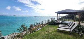 A coastal outdoor area with a wooden deck, a gazebo, and lounge chairs overlooking turquoise waters. - Private oceanfront home, 10 min drive to sandy beach
Beautiful SerenityBlu (Rolletown)