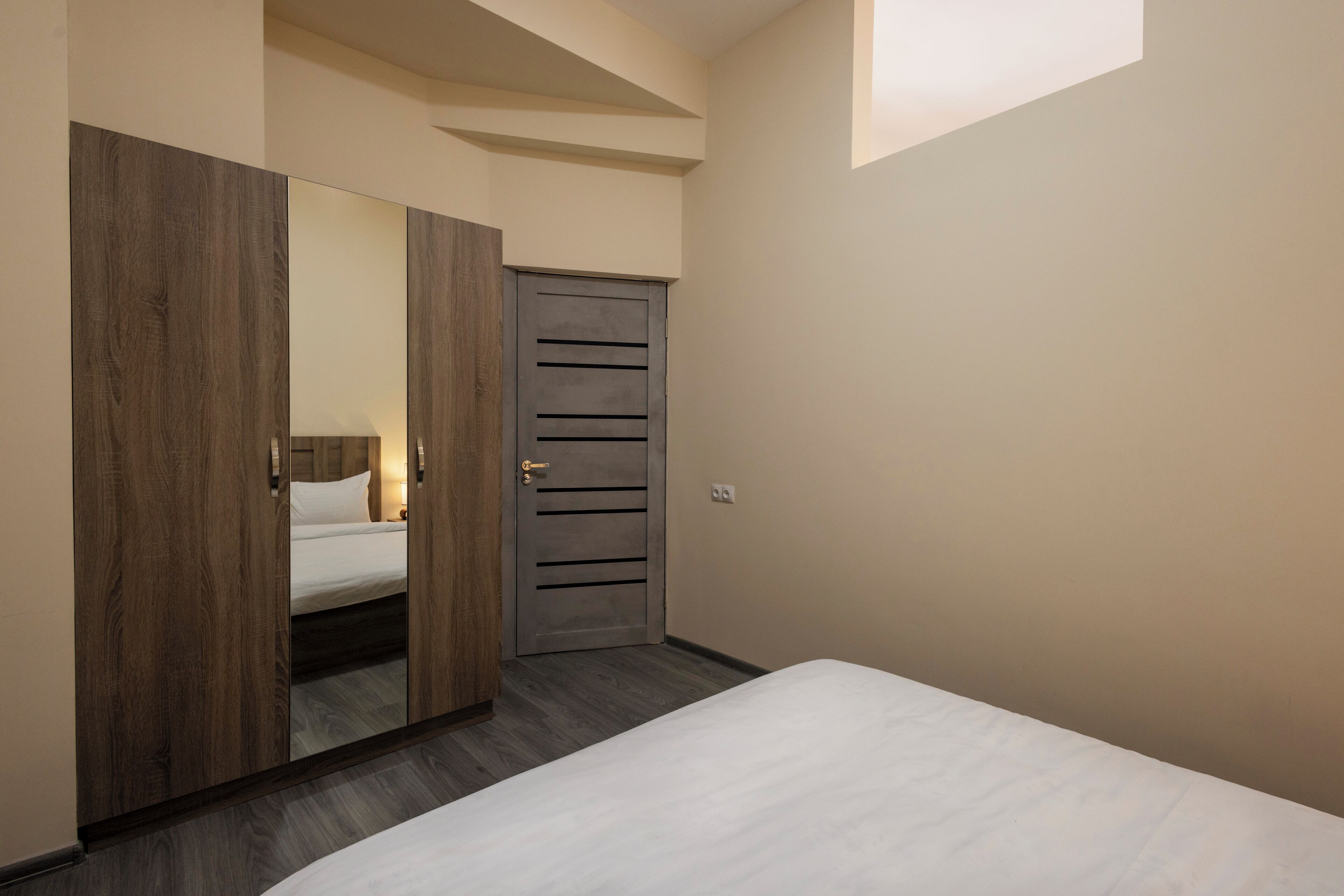 Une chambre à coucher avec un lit, une armoire et une porte.