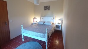 Ein Schlafzimmer mit Bett, Nachttischlampen, einer Wanduhr und einer Tür.