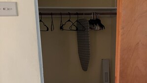 A closet with hanging clothes and a shoe rack. - Quaint 1 bedroom with a great view! Walking distance to everything! (Clearwater)