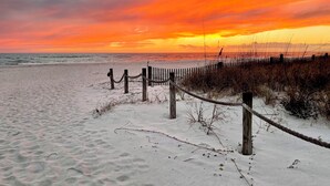 A beach with a wooden fence and rope barrier, leading to the ocean. - Surfside #11, Beautiful Beachfront Luxury Condo,  Allergy Friendly:No Pets. (Mexico Beach)