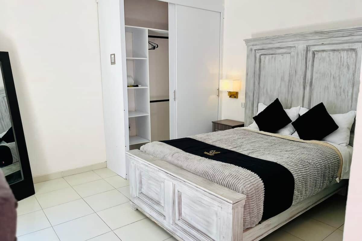 A bedroom with a bed, a wardrobe, and a nightstand.