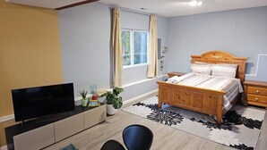 A bedroom with a bed, a TV, a desk, and a window. - Peaceful place with 360 views of the town (Snohomish)