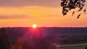 A sunset over a rural landscape with a forested hill and a small village in the distance. - Peaceful place with 360 views of the town (Snohomish)