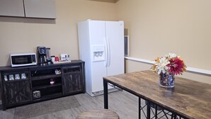 A compact kitchen with a white refrigerator, a microwave, a coffee maker, and a small cabinet with storage shelves. - Peaceful place with 360 views of the town (Snohomish)
