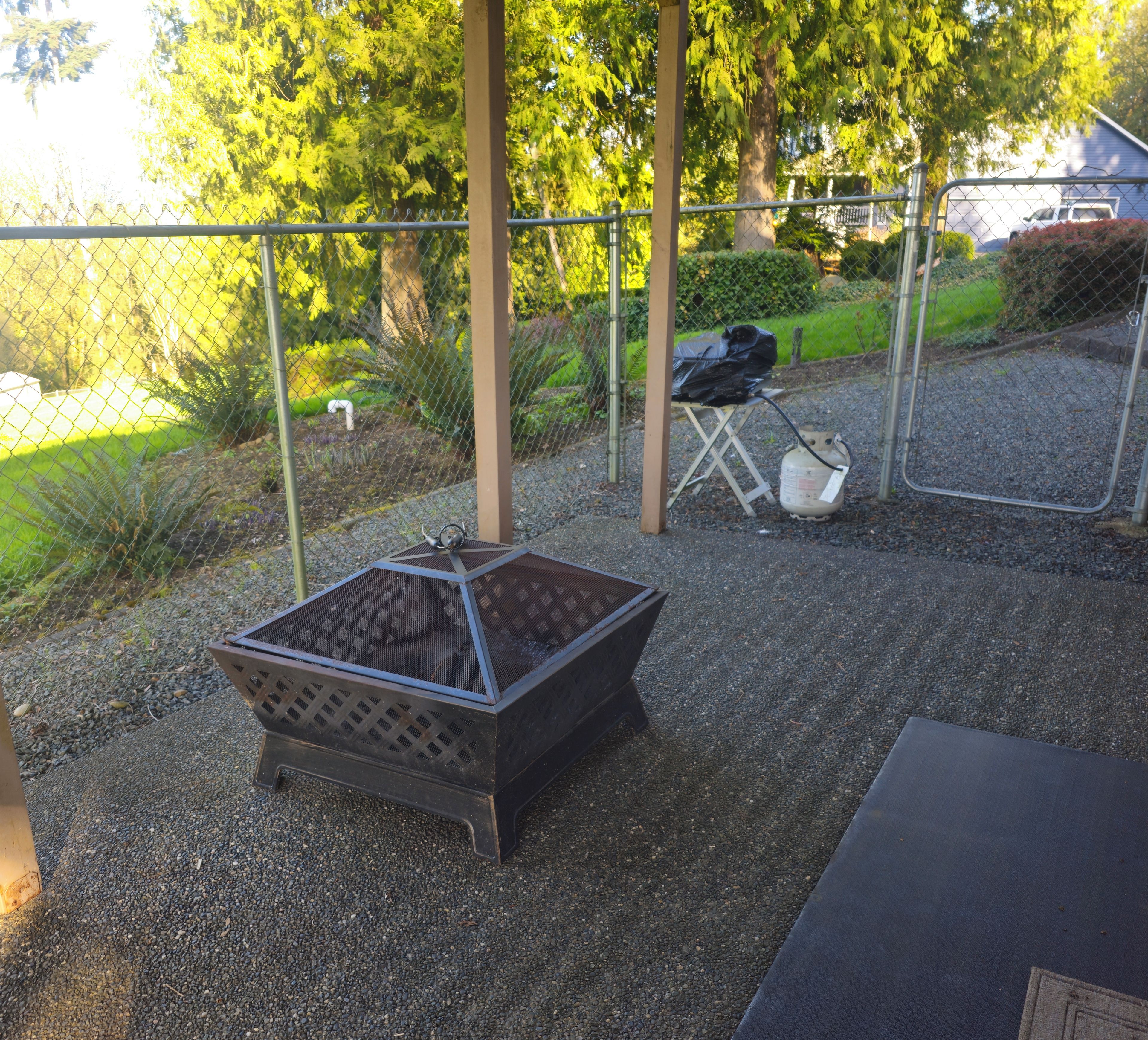 A patio area with a Galaxy S23 Ultra branded grill, a folding chair, and a table.