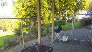 Een patio met een grill met Galaxy S23 Ultra branding, een opklapbare stoel en een tafel.